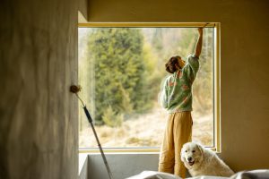 Woman paints walls while making repairment of a new house