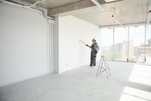 Indian Painter painting the office wall with roller paint